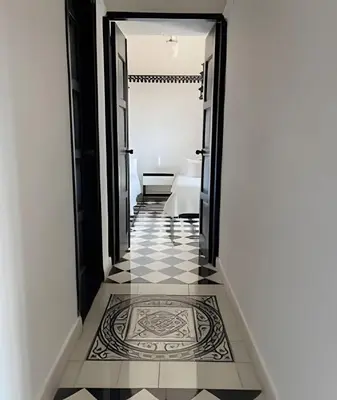a hallway with a black and white tile floor at 704 Puesta de sol apto en Cartagena in Cartagena de Indias
