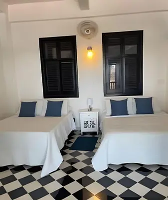 two beds in a room with a checkered floor at 704 Puesta de sol apto en Cartagena in Cartagena de Indias