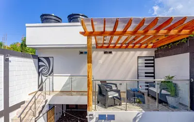 a deck with a pergola and chairs on a house at COMFORT+TRANQUILIDAD=ROMÁNTICO APARTAESTUDIO CON PISCINA #6 in Santa Marta