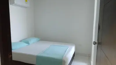 a small white bed in a room with a window at Apartamento 3 Carabelas Cartagena Piso 16 in Cartagena de Indias
