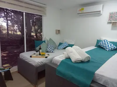 two beds in a room with blue and white pillows at CABAÑA EN ISLA FRENTE A CARTAGENA in Cartagena de Indias