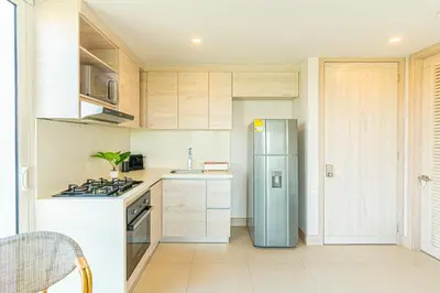 a kitchen with a stainless steel refrigerator and cabinets at Lujoso Apto Cartagena - Acceso Directo a la Playa in Cartagena de Indias
