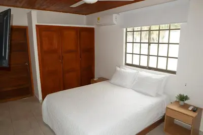 a bedroom with a white bed and a window at Cabaña Macondo in Coveñitas