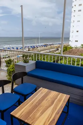a blue bench on a balcony with the beach at King's Apartments 302 in Cartagena de Indias
