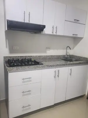 a white kitchen with a stove and a sink at Apartment by the sea in Puerto Colombia