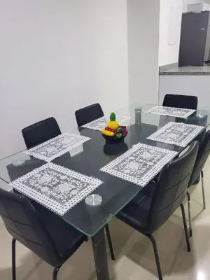 a black table with chairs and a bowl of fruit on it at Apartment by the sea in Puerto Colombia