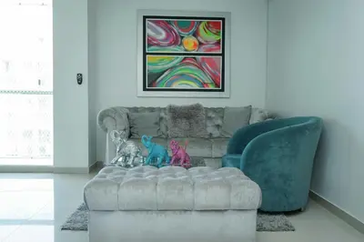 a living room with a couch and a painting at Apartamento moderno y centrado en Barranquilla in Barranquilla