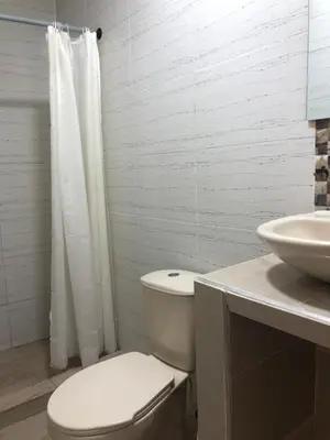 a white bathroom with a toilet and a sink at Martinica Hostel in Cartagena de Indias