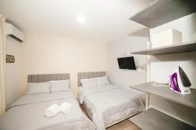 a bedroom with two beds and a desk with a computer at Abel Boutique House in Cartagena de Indias