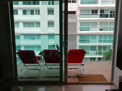 two chairs sitting on a patio outside a window at APARTAMENTO MORROS922 LA BOQUILLA con acceso directo a la Playa in Cartagena de Indias