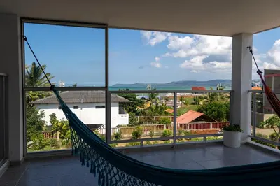 a hammock on a balcony with a view of the ocean at Villa Nuevo Amanecer Santa Verónica in Santa Veronica
