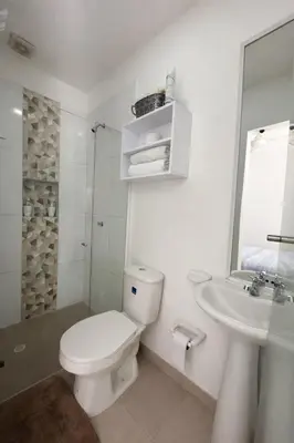 a white bathroom with a toilet and a sink at Aparta estudios Mubarak in Barranquilla