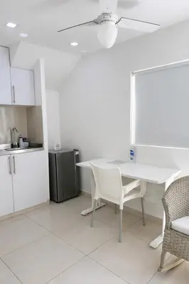 a kitchen with a white table and chairs at Aparta estudios Mubarak in Barranquilla