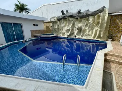 a swimming pool in a backyard with a rock wall at Casa palma Cartagena de Indias, Colombia in Cartagena de Indias