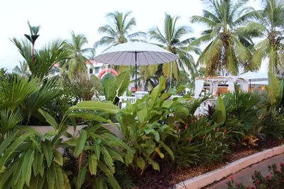 a patio with a table and an umbrella and plants at VAIA HOTELES in Coveñas