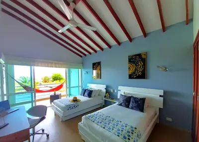 a bedroom with two beds and a ceiling fan at Beach Villa Sol & Mar Cartagena, beachfront & private pool in Cartagena de Indias
