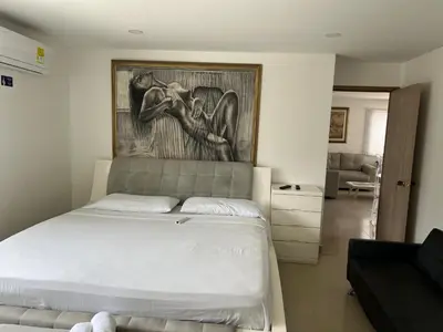 a bedroom with a bed with a painting on the wall at Apartamento con vista al mar in Cartagena de Indias