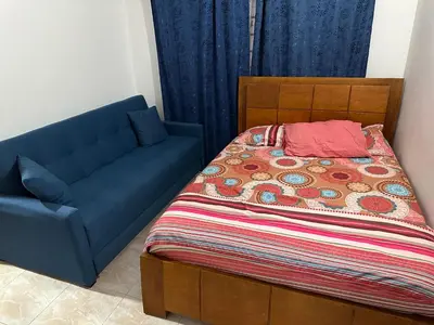 a bedroom with a bed and a blue couch at Cabaña #5 en Condominio Mar de Coveñas in Coveñas