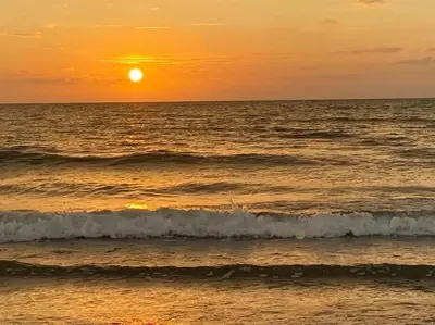 a sunset over the ocean with waves in the water at Apartamento vista al Mar lateral Panoramic View,Spectacular building,Pools, Beach Morros zoe ultimo piso in Cartagena de Indias