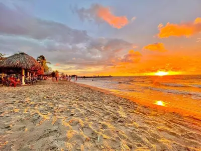 a beach with a hut and the ocean at sunset at Condominio, Cabaña 202 in Puerto Viejo