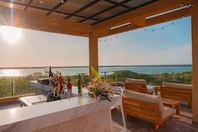 a patio with a bar with a view of the ocean at Hotel Explore Caño Dulce in Tubará