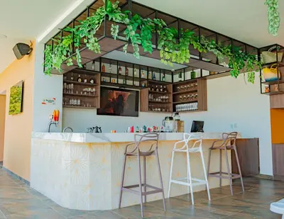 a bar in a restaurant with plants on the wall at Hotel Explore Caño Dulce in Tubará
