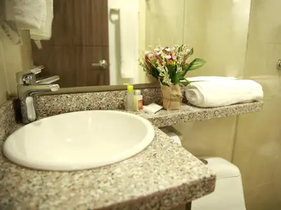 a bathroom counter with a sink and flowers on it at Hotel Prado 72 INN in Barranquilla