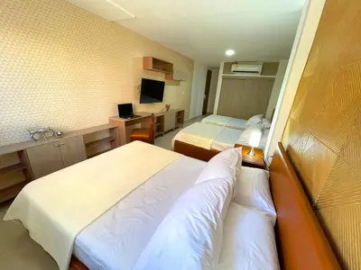 a hotel room with two beds and a desk at Hotel Prado 72 INN in Barranquilla