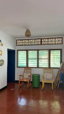 a living room with two chairs and windows at Cabaña Coveñas Los García in Coveñas