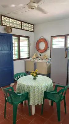 a room with a table and two chairs and a table with flowers at Cabaña Coveñas Los García in Coveñas