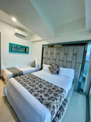 a bedroom with two beds and a large headboard at TU VISTA IDEAL in Cartagena de Indias