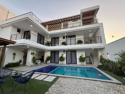 a house with a swimming pool in front of it at Cabaña Milagro Bonito in Santa Marta