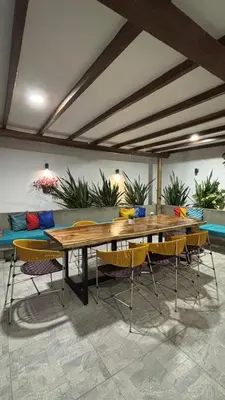 a table and chairs in a room with a couch at Cabaña Milagro Bonito in Santa Marta