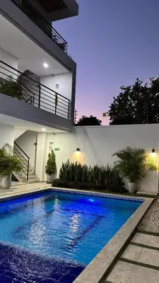 a swimming pool in front of a house at Cabaña Milagro Bonito in Santa Marta