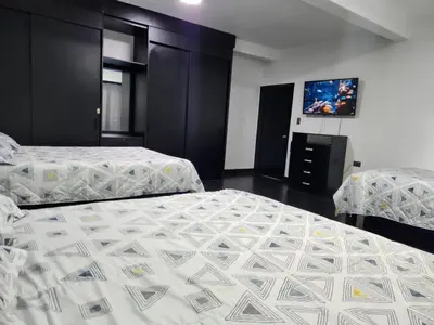 a bedroom with two beds and a flat screen tv at Cabaña los Abuelos in Coveñas