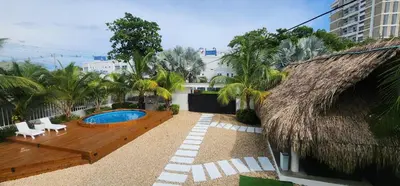 a resort with a swimming pool and a thatch roof at Cabaña los Abuelos in Coveñas