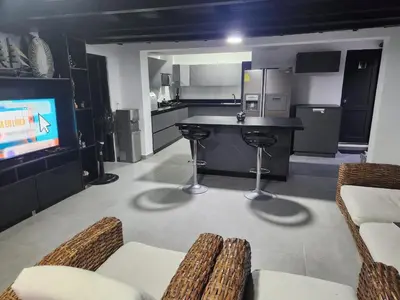 a kitchen with a bar and a tv in a room at Cabaña los Abuelos in Coveñas