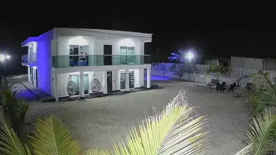 a white house with blue lights on it at night at Cabaña los Abuelos in Coveñas