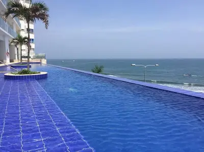 a large blue swimming pool next to the ocean at Apartamento con vista al mar in Cartagena de Indias