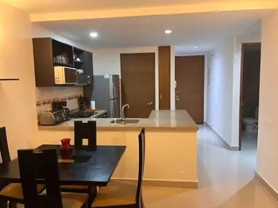 a kitchen with a counter and a table with chairs at Apartamento con vista al mar in Cartagena de Indias