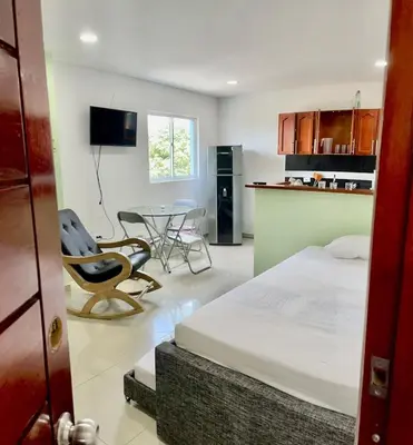a bedroom with a bed and a table and a kitchen at Apartamento 403 in Cartagena de Indias