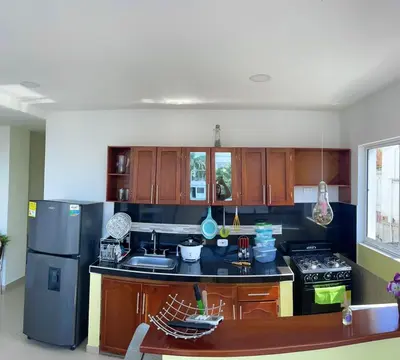 a kitchen with wooden cabinets and a stove and refrigerator at Apartamento 301 in Cartagena de Indias