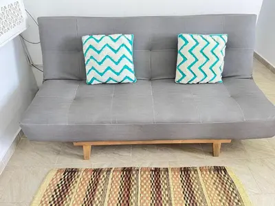a gray couch with two pillows on top of a rug at Coveñas Apartamento vacacional caribe campestre 9-502 in Coveñas
