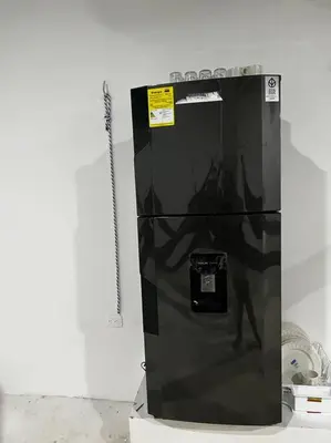 a black refrigerator sitting on top of a counter at Habitación confortable y terraza Hamacas Coveñas in Coveñas