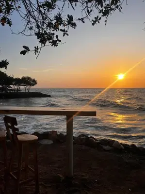 a table and chairs on the beach with the sunset at Habitación confortable y terraza Hamacas Coveñas in Coveñas