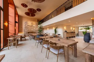an empty restaurant with wooden tables and chairs at Osh Hotel Cartagena in Cartagena de Indias