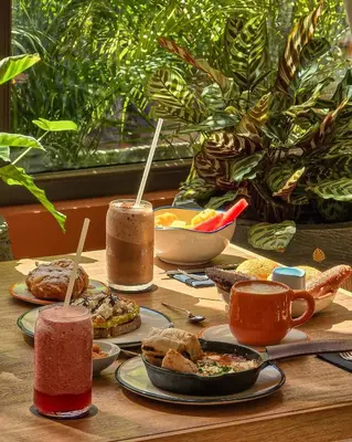 a wooden table topped with plates of food and drinks at Osh Hotel Cartagena in Cartagena de Indias
