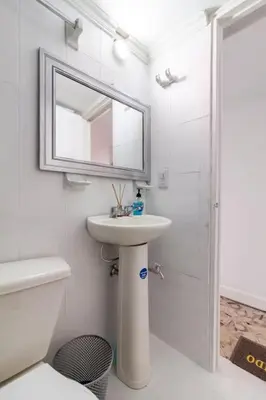 a white bathroom with a sink and a mirror at Apartamento cerca al Mar in Cartagena de Indias