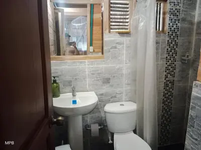 a bathroom with a toilet and a sink and a mirror at Bungalow Palmar del Viento by AMAUNA in Moñitos