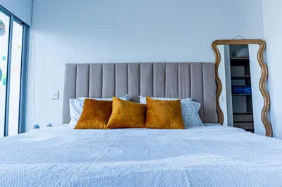 a bed with yellow pillows in a blue bedroom at Apartamento en Bocagrande Cartagena in Cartagena de Indias
